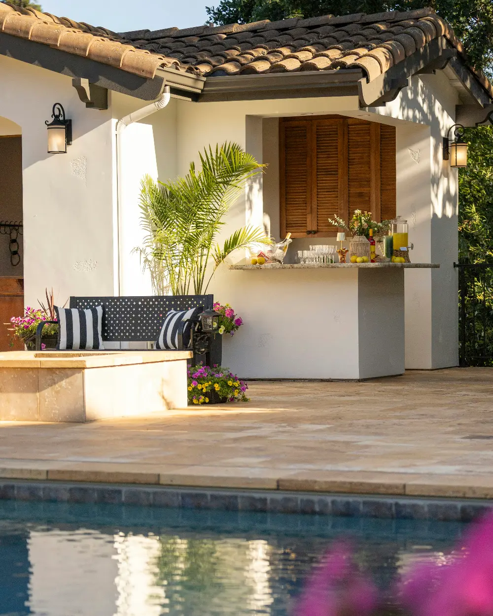 Barra exterior con bebidas y zona de estar junto a la piscina